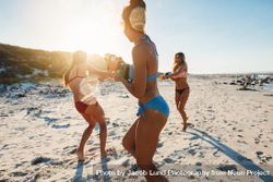 Fit group of women playing with squirt guns at the beach 5lqx74