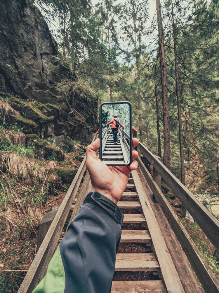 Tourist taking photo while walking on footpath