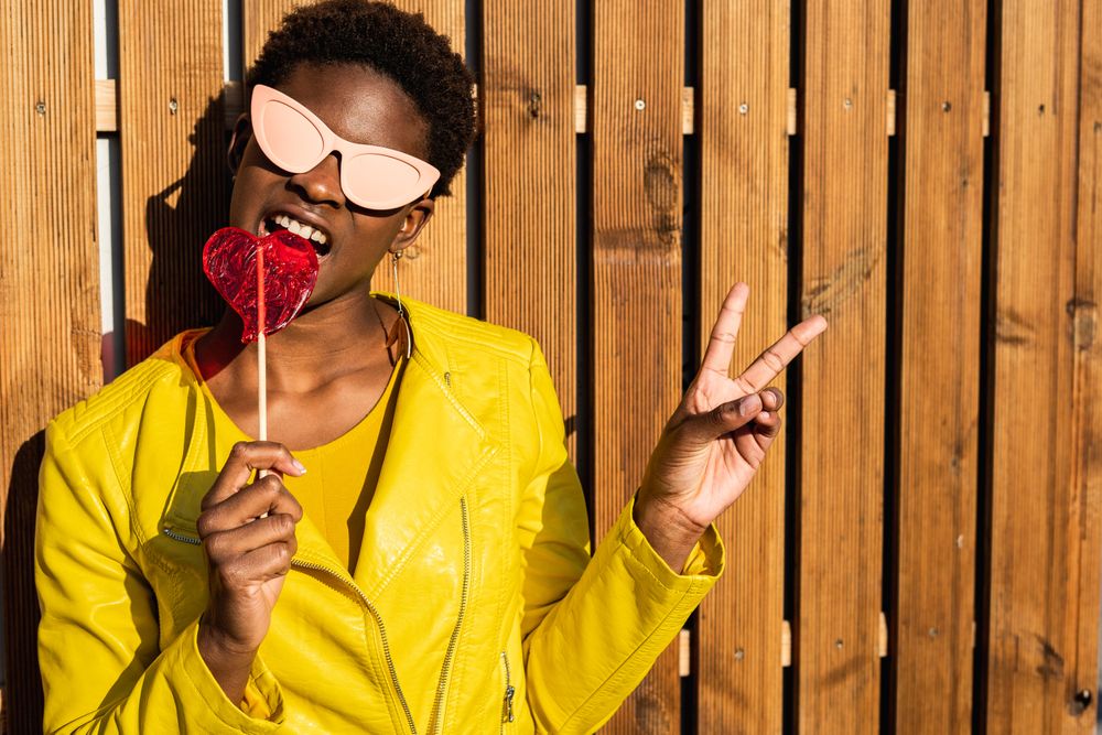 Cool female eating candy and showing v sign