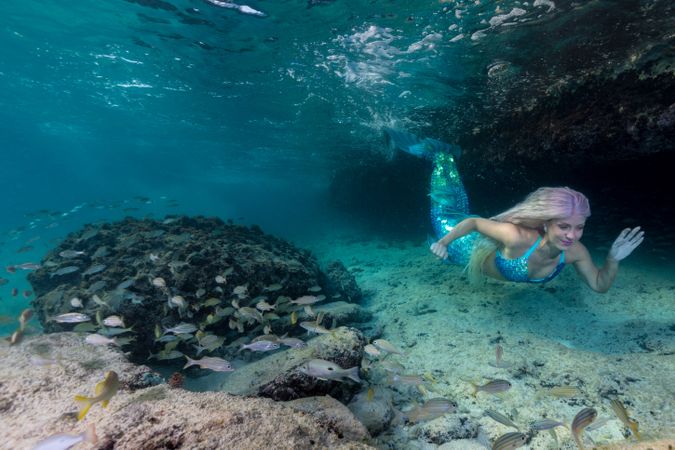 Redhead fairytale female mermaid swimming underwater