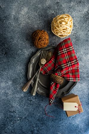 Top view of rustic Christmas table setting with tartan napkin