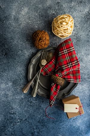 Top view of rustic Christmas table setting with tartan napkin