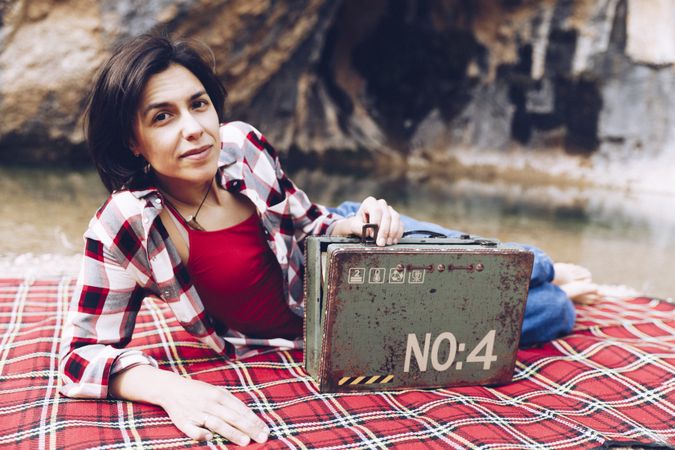 Cheerful woman with old case on picnic