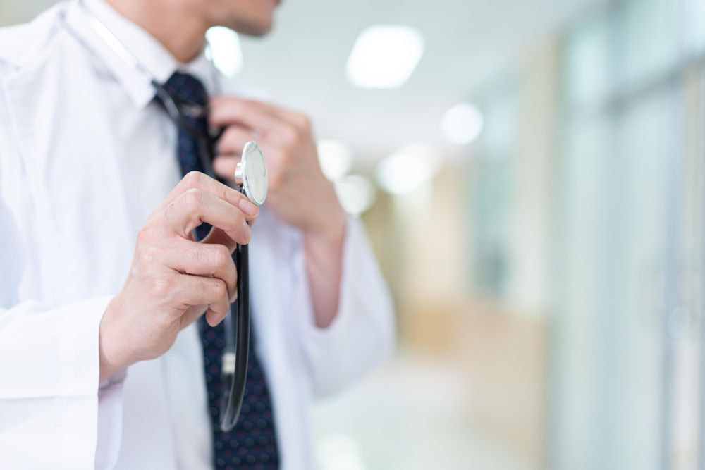 Doctor with stethoscope in bright hallway