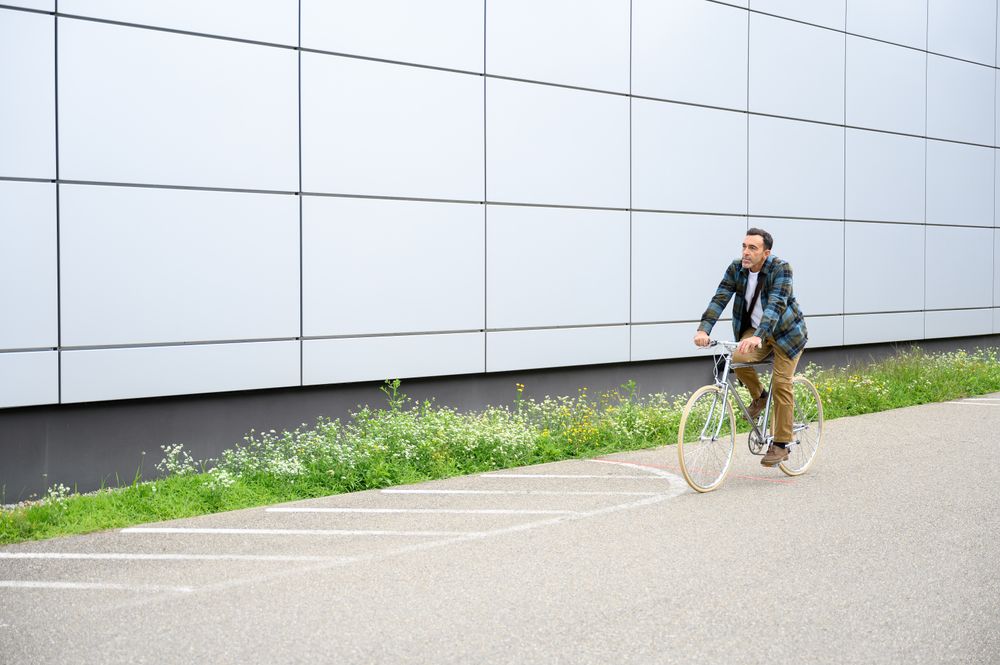 Smiling man with bicycle on road