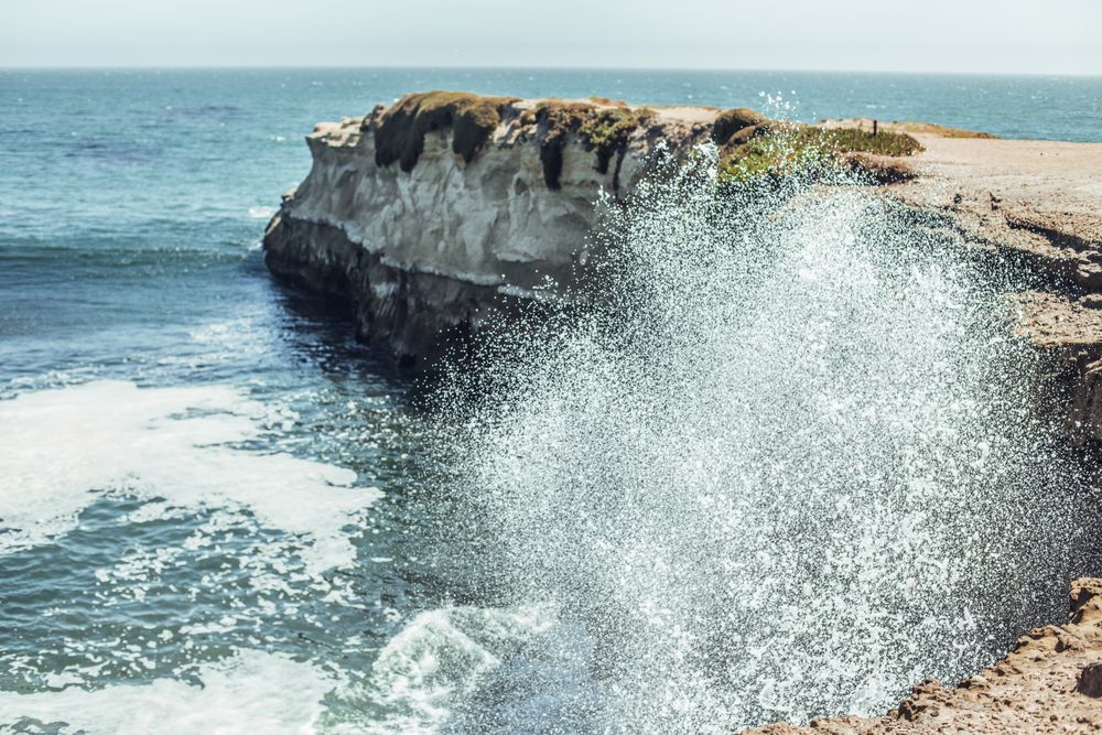 Water with splashes near coast in sunny day