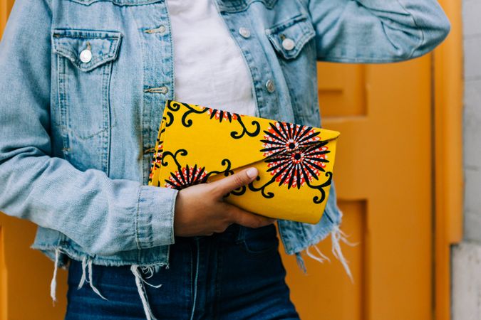 crop Stylish female by yellow door with handbag