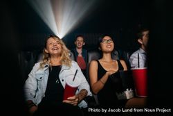 Young women and men watching movie in cinema 0JAQnb