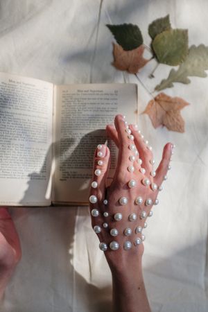 Cropped image of hand with pearls turning a page