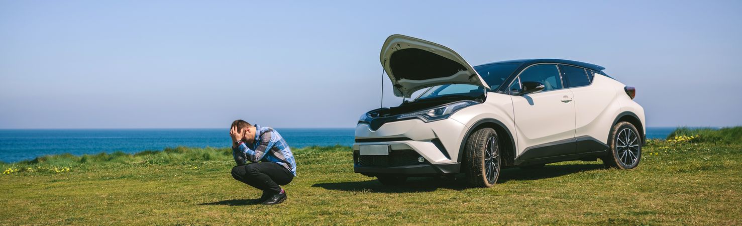 Young man desperate, car broken down
