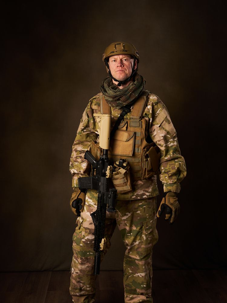 a young military soldier with automatic airsoft rifle with telescopic vision