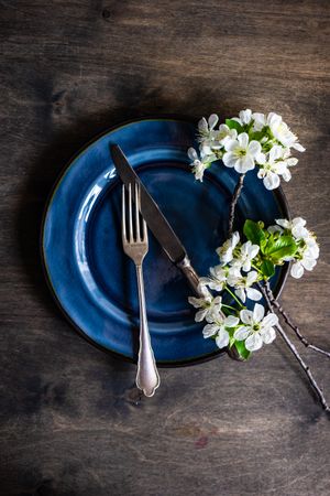 Top view of flowers on blue plate for spring table setting
