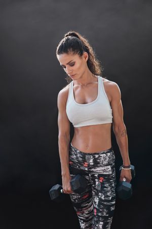 Beautiful fitness instructor on dark background