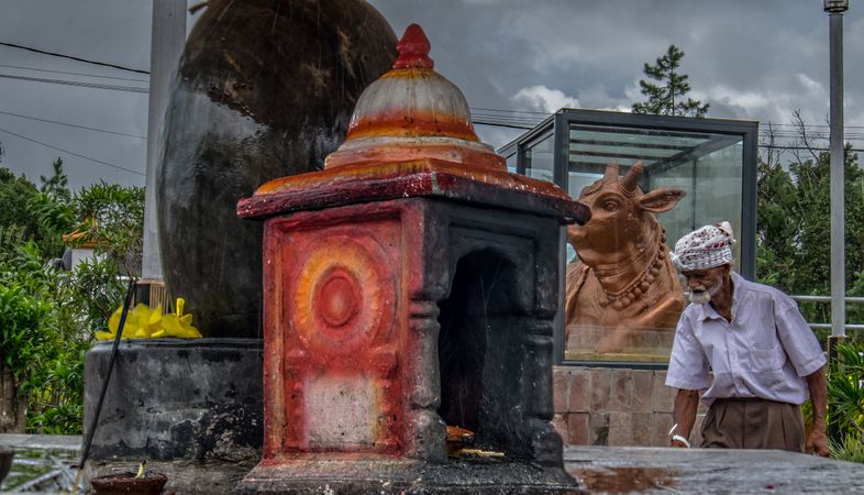 A custodian maintaining the Hindu sacred temple on cloudy day