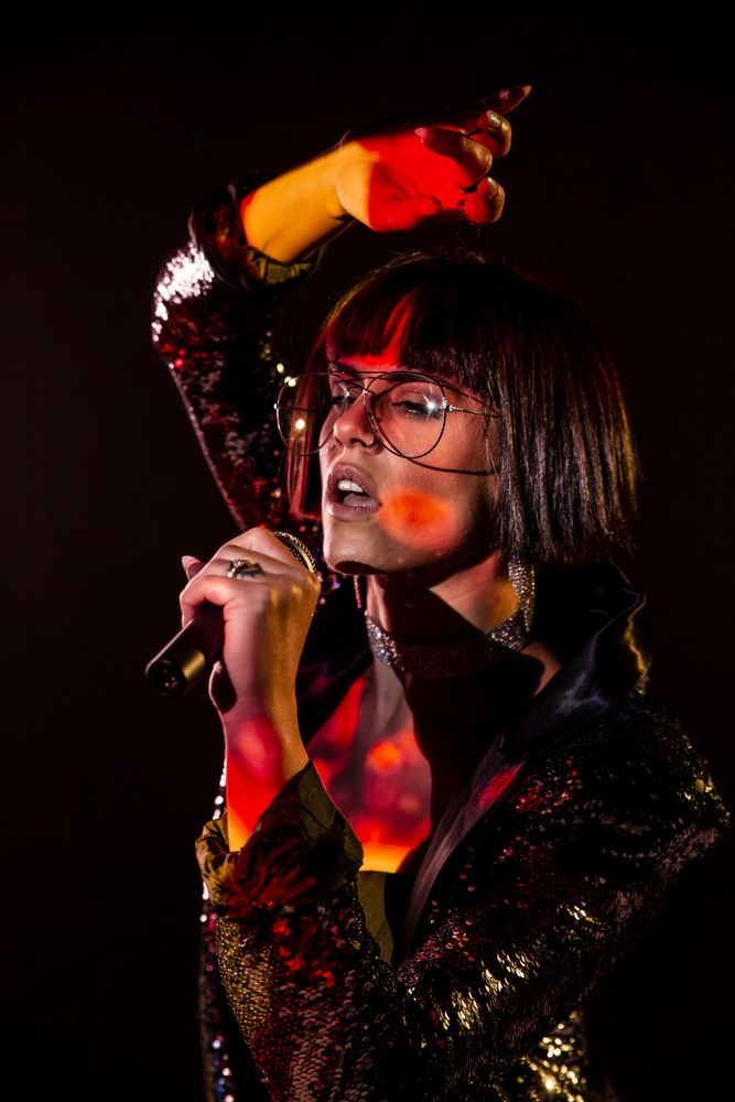 Stylish woman singing on stage