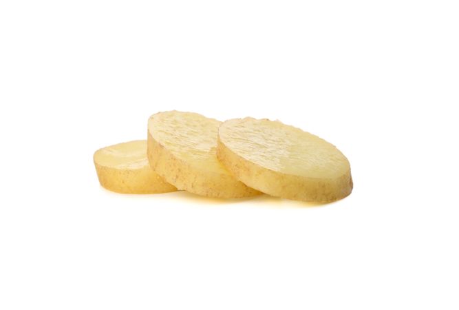 Potato slices lined up on plain background