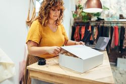 Fashion store owner preparing a package for shipment