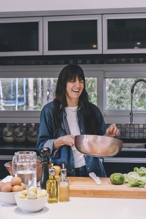Smiling woman holding a wok