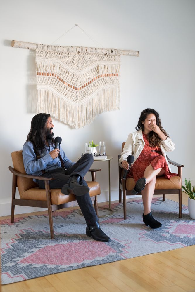 Woman laughing at man while both are giving a talk