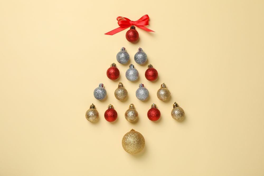 Christmas tree made of baubles on beige background, space for text