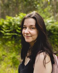 Portrait of a young woman, wearing a t-shirt and brown hair, during a walk in nature