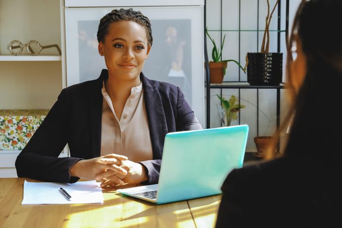 Woman business owner listening in a meeting with colleague in bright office