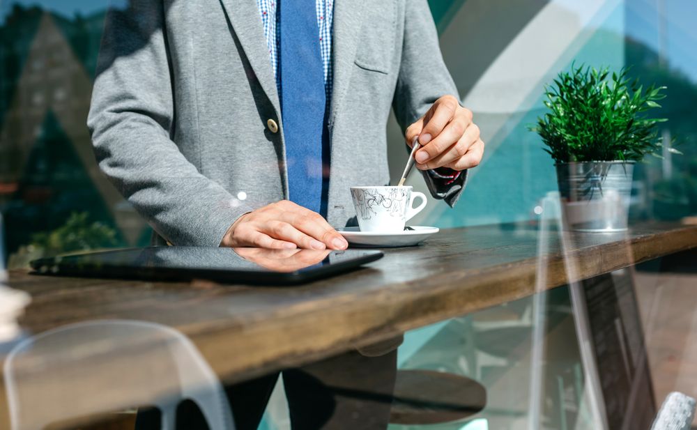 Unrecognizable businessman stirring coffee