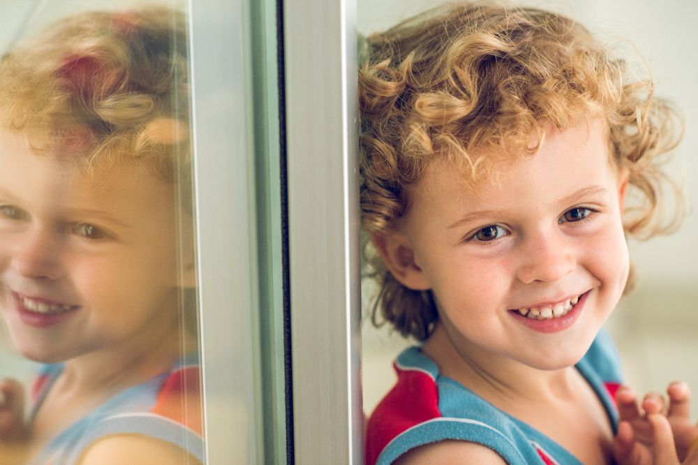 Happy boy sitting near window
