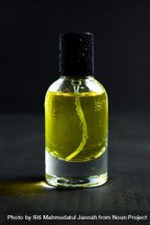 Yellow glass bottle with droplets in dark studio bxAzyy