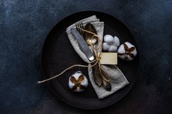 Top view of plate with decorative cotton and feathers with napkin with space for text