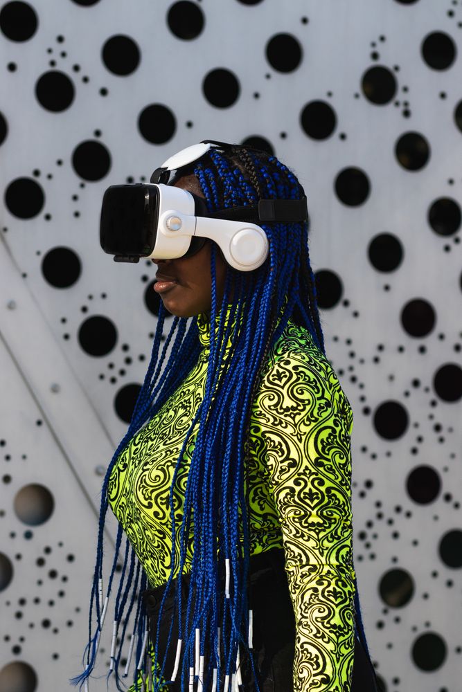 Black woman in VR headset in city