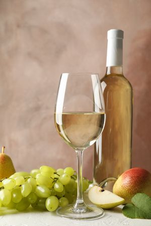 Pears, grape, bottle and glass with wine on plain background, copy space