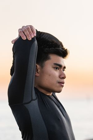 sportsman stretching shoulders near sea