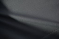 Wavy dark grey fabric background texture. shiny, glossy and elegant background.