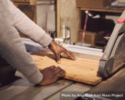 Black man cutting wood in studio 5o62x0
