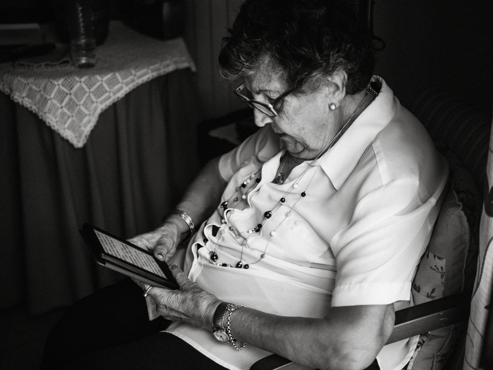 Older female reading e-book at home