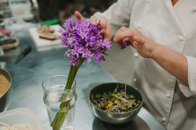 Woman preparing salad by hands at decorated table