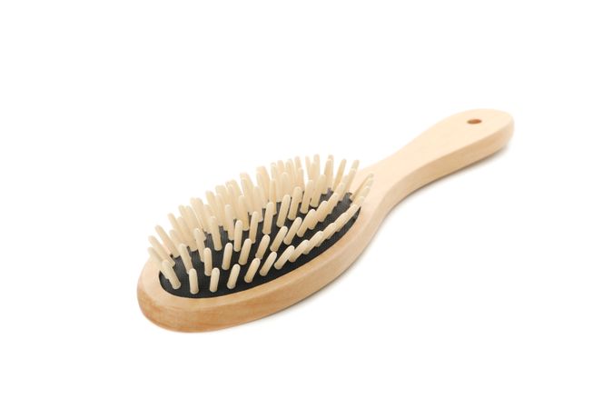Wooden hair brush isolated on light background