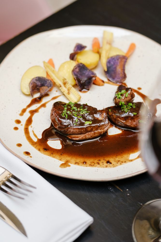 Delicious dinner with beef steaks and red wine in restaurant