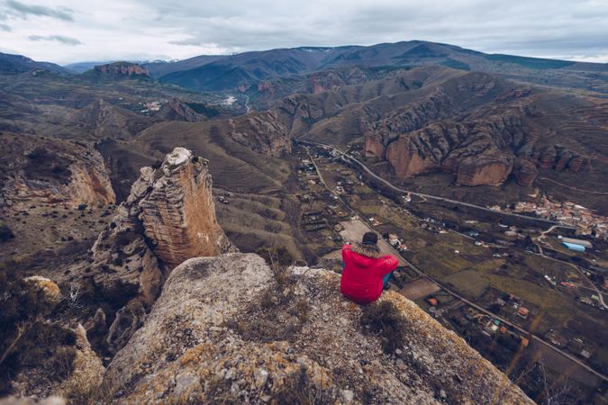 Person rest on cliff sitting in edge and looking down