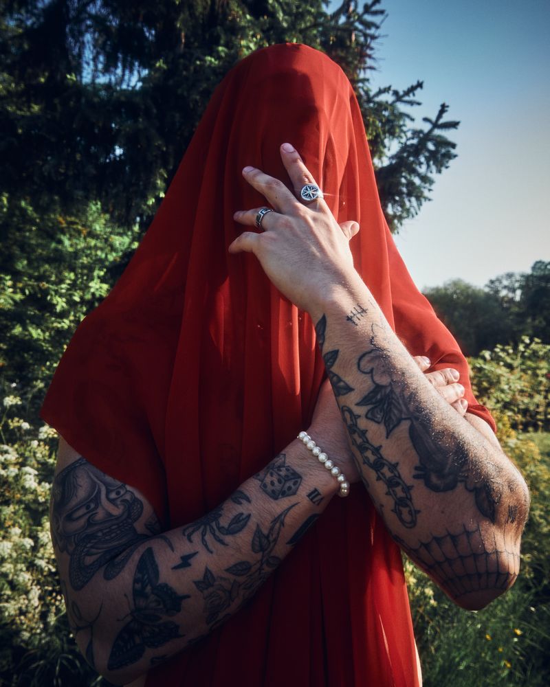 Tattooed male with red sheet on his head