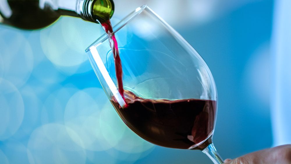 Man Pouring Red Wine into Wine Glass.