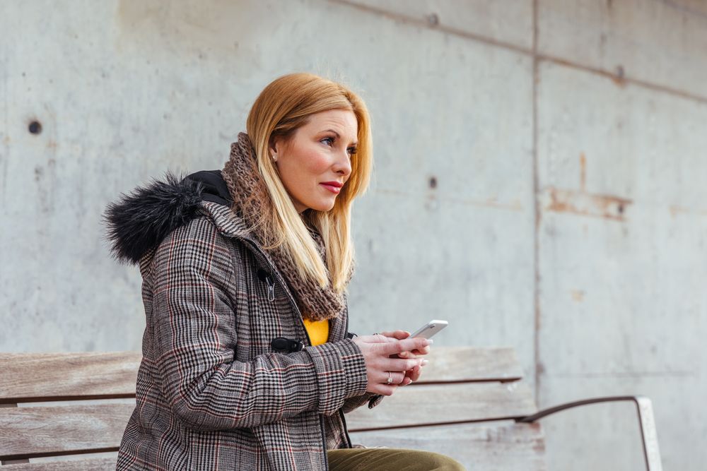 Portrait of blonde woman using her mobile phone