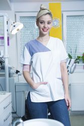 Happy female dentist in office with hand in pocket