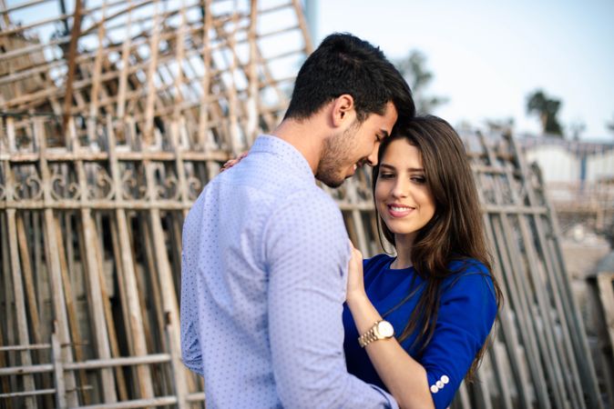 Loving couple hugging in abandoned building with metal fence