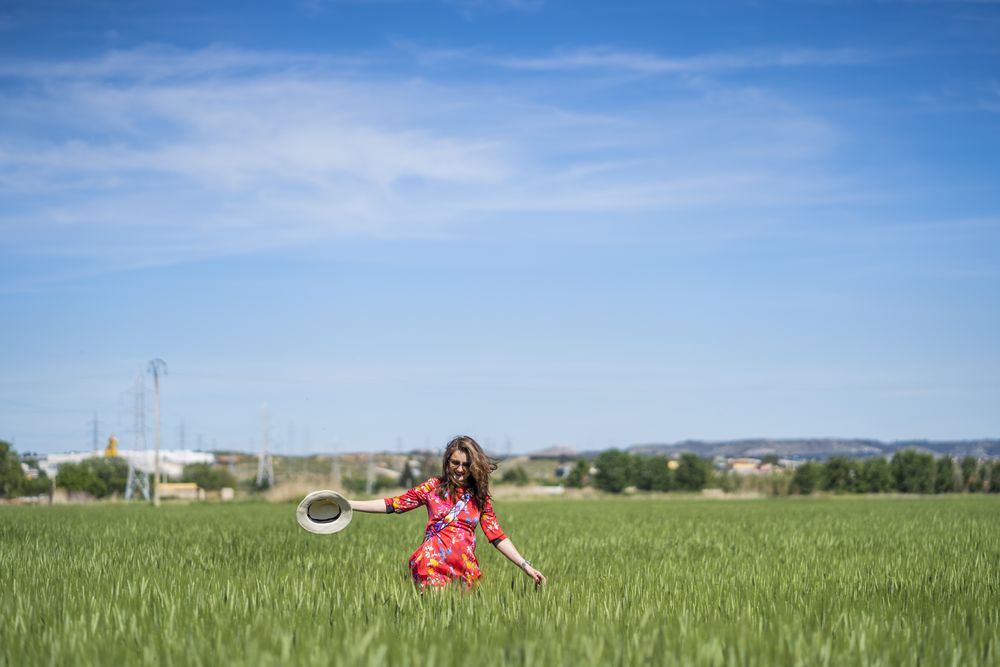 Young woman throwing up hat in field