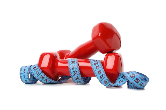 Dumbbells and measuring tape isolated on blank background, weight loss