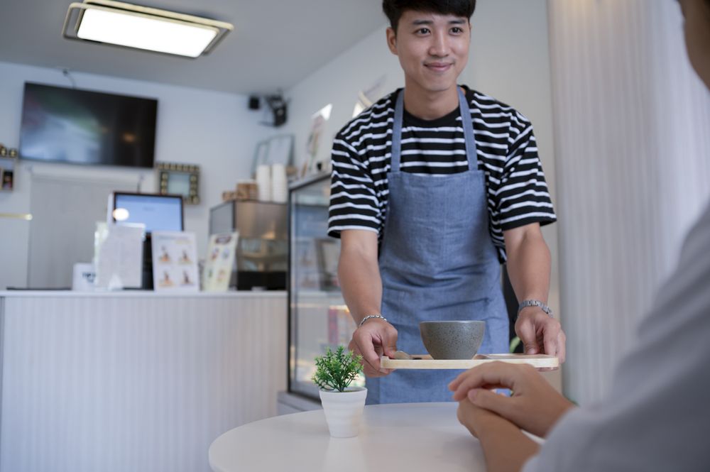 Barista serving coffee in a cafe, serving in a cafe.