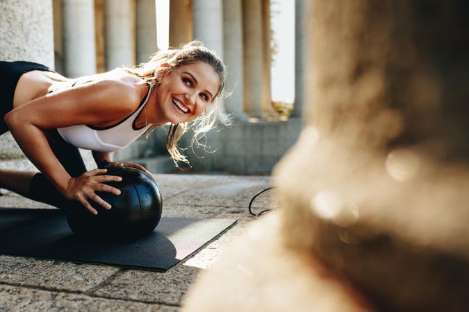 Fitness woman doing push-ups  on a yoga mat