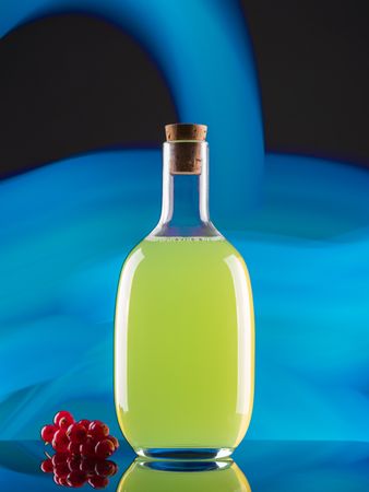 Bottle with drink near berries